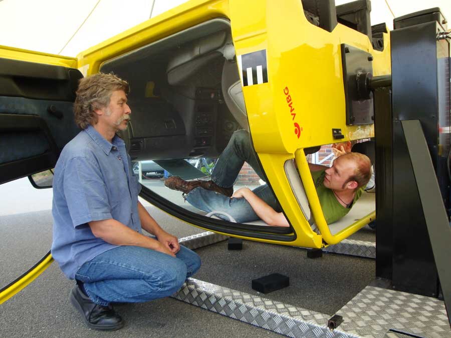 Mitarbeiter im gelben auf dem Kopf stehenden Auto